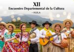 Artistas huilenses celebran el XII Encuentro Departamental de la Cultura con trajes típicos, instrumentos y artesanías en un paisaje montañoso con arrozales y un puente.